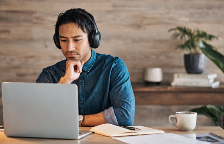 Man with headphones sitting at his laptop